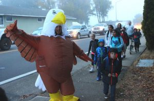 Prairie Mountain eagle mascot leading students down the sidewalk
