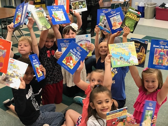 group of children holding up books