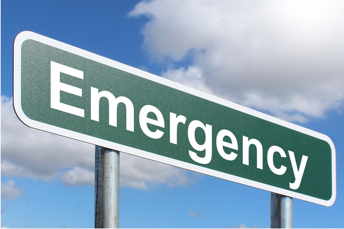 green and white sign that says emergency against a blue sky background