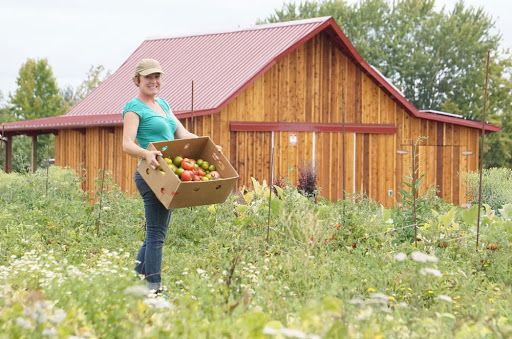 Bethel Farm with a woman holding a basket standing in front of it
