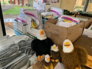 toy stuffed eagles posing on boxes and bags of school supplies
