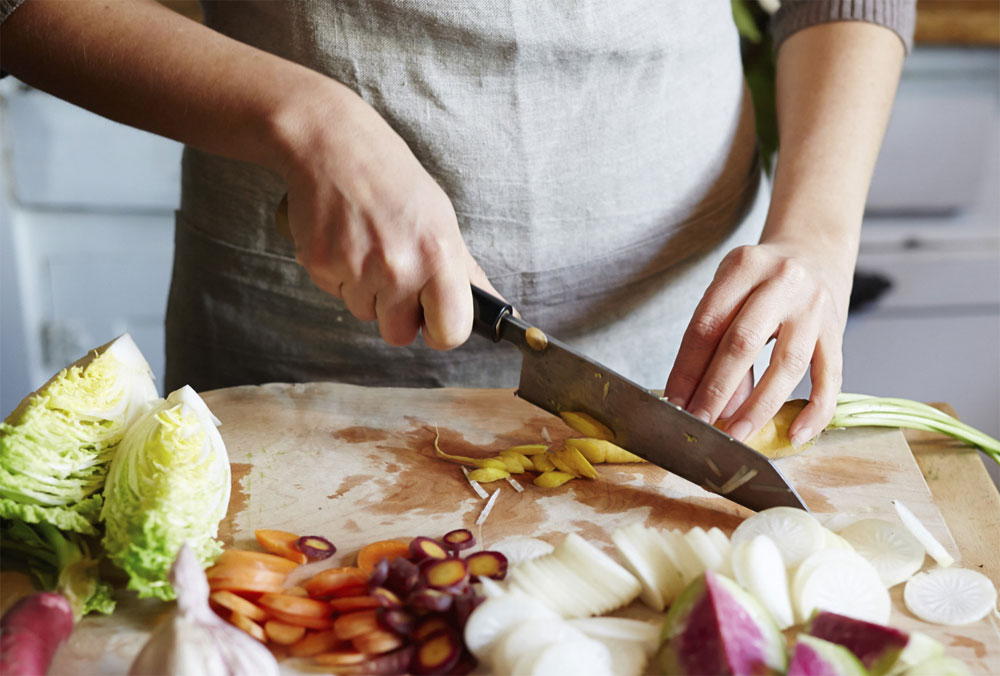 person cutting vegetables with a knife