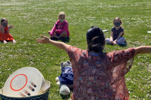 Teacher on the grass with students.