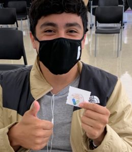 student wearing a mask giving thumbs up gesture