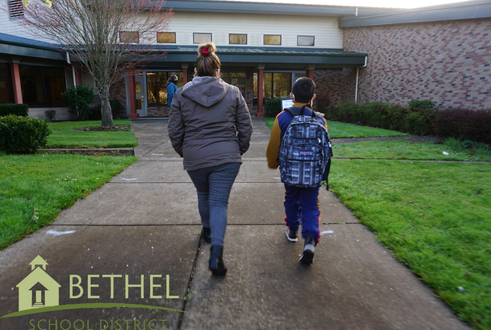 parent and student walk toward school