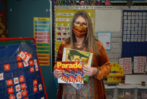 Jeni Davidson, a Malabon teacher, hold up several books in her classroom.