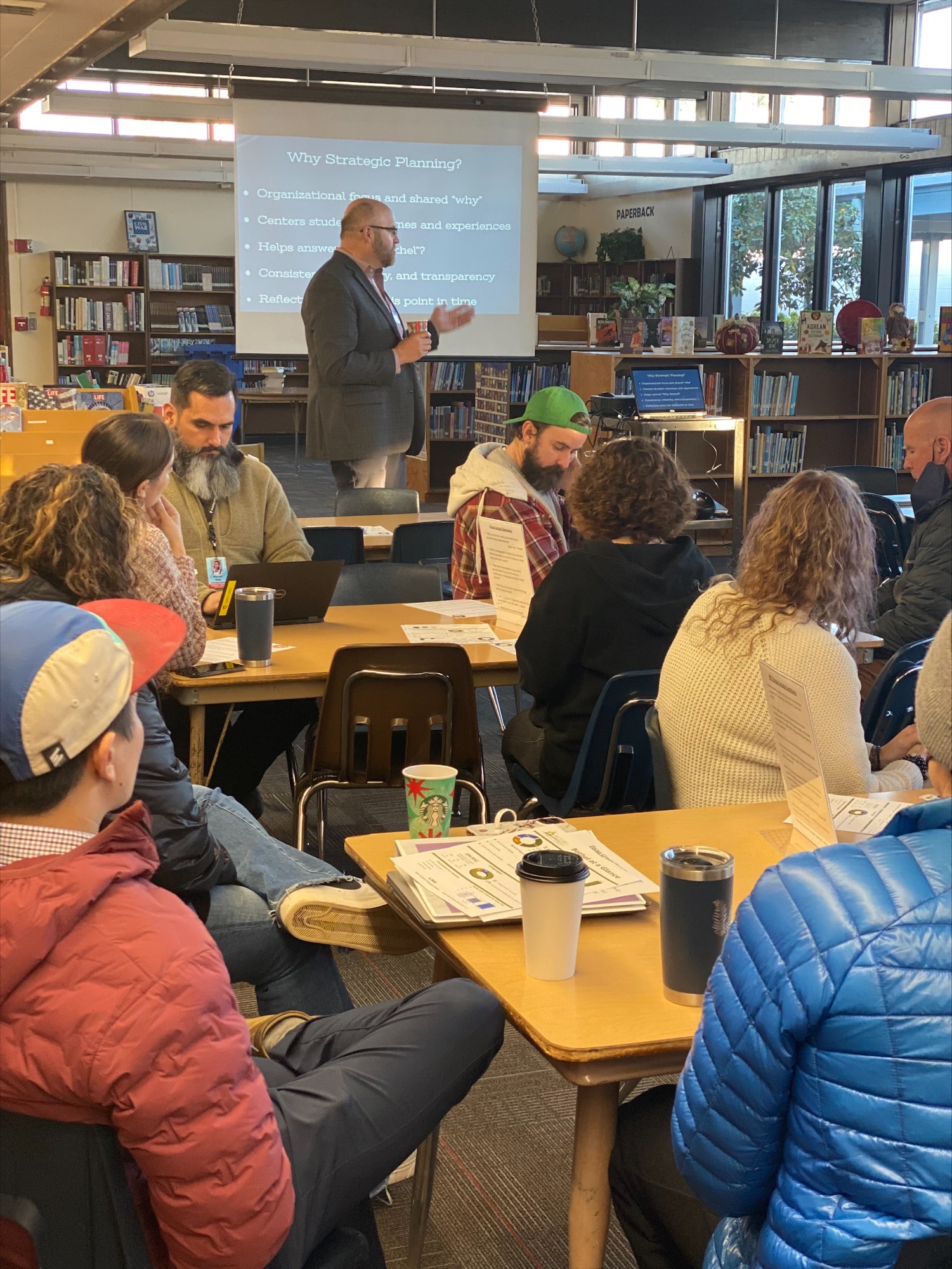 Bethel Superintendents explaining strategic visioning process to group of employees in library of Shasta Middle School. 